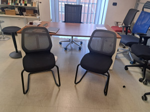 Sedia ospiti a slitta modello SeDo con schienale in rete e seduta imbottia e rivestita in tessuto nero ignifugo