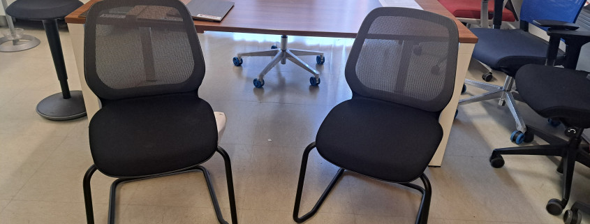 Sedia ospiti a slitta modello SeDo con schienale in rete e seduta imbottia e rivestita in tessuto nero ignifugo